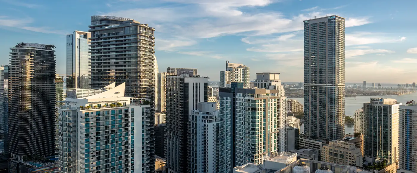 Residential high-rise towers in the Brickell neighborhood of Miami with Biscayne Bay behind them, pictured for condo insurance Florida owners