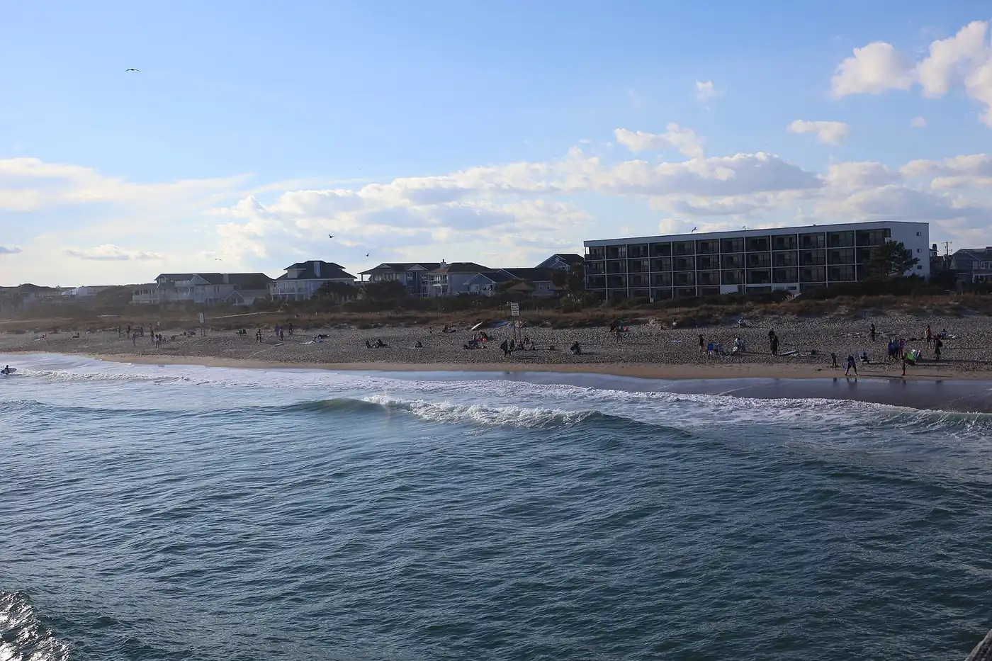 Condo insurance North Carolina: an oceanfront mid-rise building beside beach houses on the coast